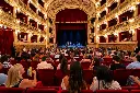 Teatro storico gremito illuminato d’oro.webp