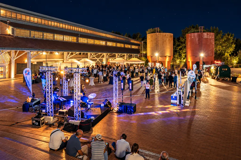 Festa notturna nel cortile industriale.webp