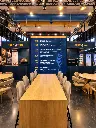 Stand espositivo Molino Magri con tavoli e palinsesto.webp