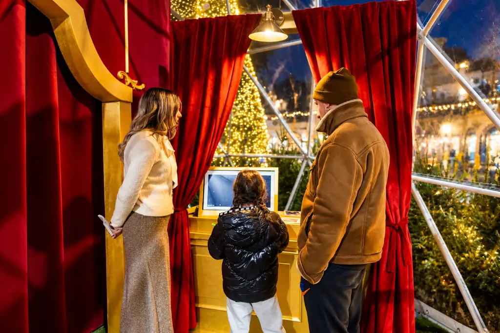 Famiglia nel chiosco natalizio luminoso.webp