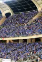 Folla blu sotto gli archi dello stadio.webp