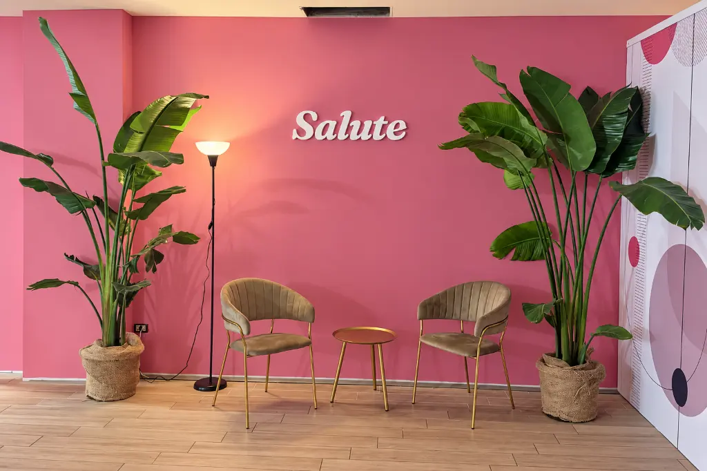 Interno editoriale rosa con poltrone e piante.webp